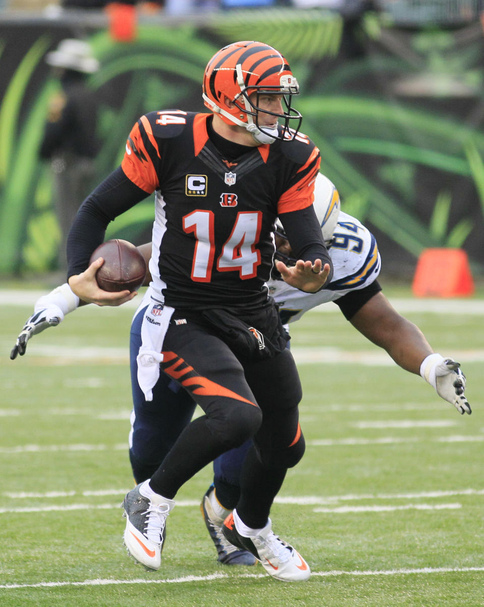 Cincinnati Bengals quarterback Andy Dalton (14) is chased by San Diego Chargers defensive end Corey Liuget in the second half of an NFL wild-card playoff football game on Sunday, Jan. 5, 2014, in Cincinnati. (AP Photo/Tom Uhlman)