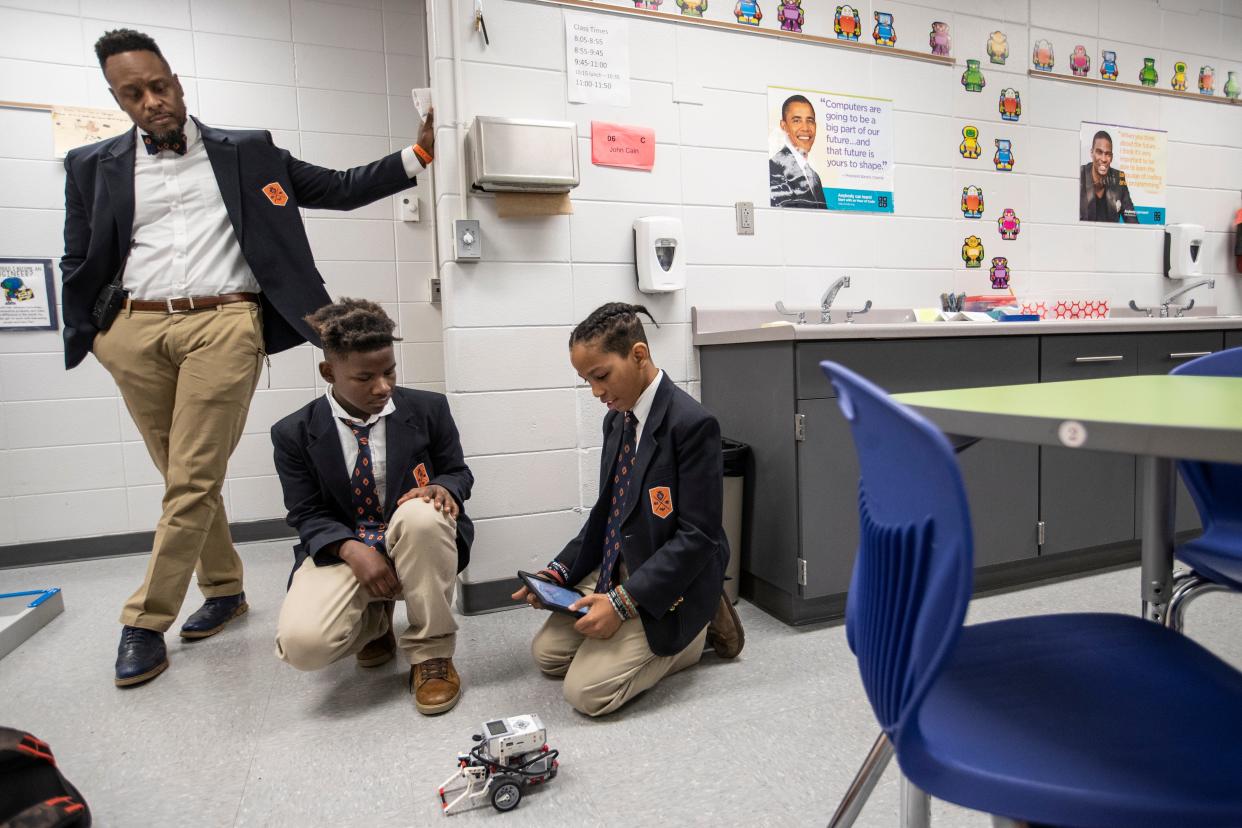 Principal Robert Gunn Jr. watches as Andres Rodriguez, right, and Paul Thompson, center, put a robot through a series of tests during STEM class at the DuBois Academy. Dec. 12, 2018