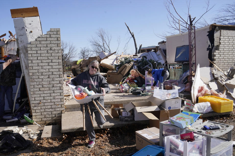 Belinda Penner carries belongings from her cousin's home after a tornado tore through the area in Wayne, Okla. (Sue Ogrocki / AP)