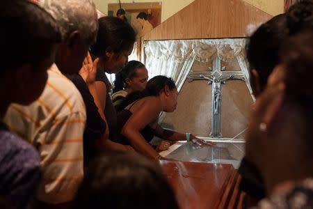 Eubardis Herrera reacts next to the coffin of her daughter Alexandra Conopoy, a pregnant 18 year-old killed during an incident over scarce of pork, according to local media, in Charallave, Venezuela January 1, 2018. Picture taken January 1, 2018. REUTERS/Adriana Loureiro