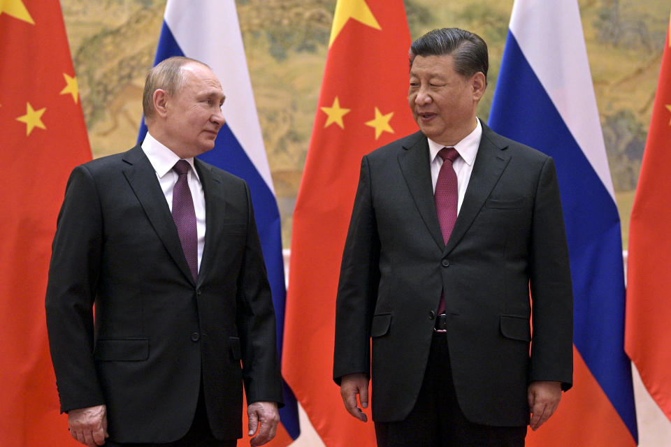 Chinese President Xi Jinping, right, and Russian President Vladimir Putin talk to each other during their meeting in Beijing, Friday, Feb. 4, 2022.