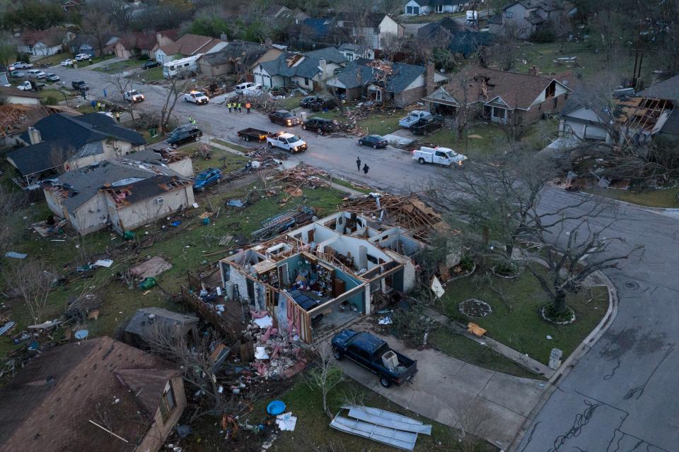 A search and rescue team is seen as residents walk past destroyed homes in the aftermath of a tornado in Round Rock on Tuesday (REUTERS)