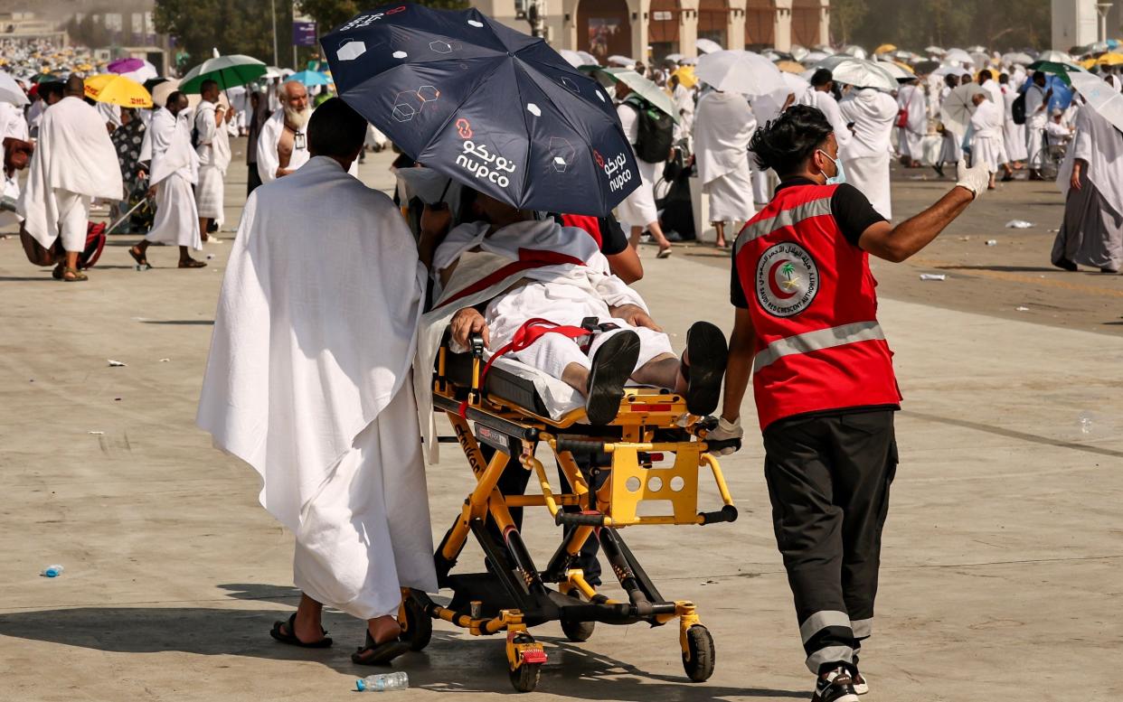 Medical team evacuate a pilgrim affected by the scorching heat, at the base of Mount Arafat, during the hajj pilgrimage