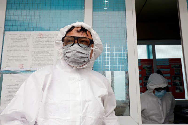 Vietnamese health workers wearing protective suits stand guard at Huu Nghi border gate connecting with China, in Lang Son province, Vietnam