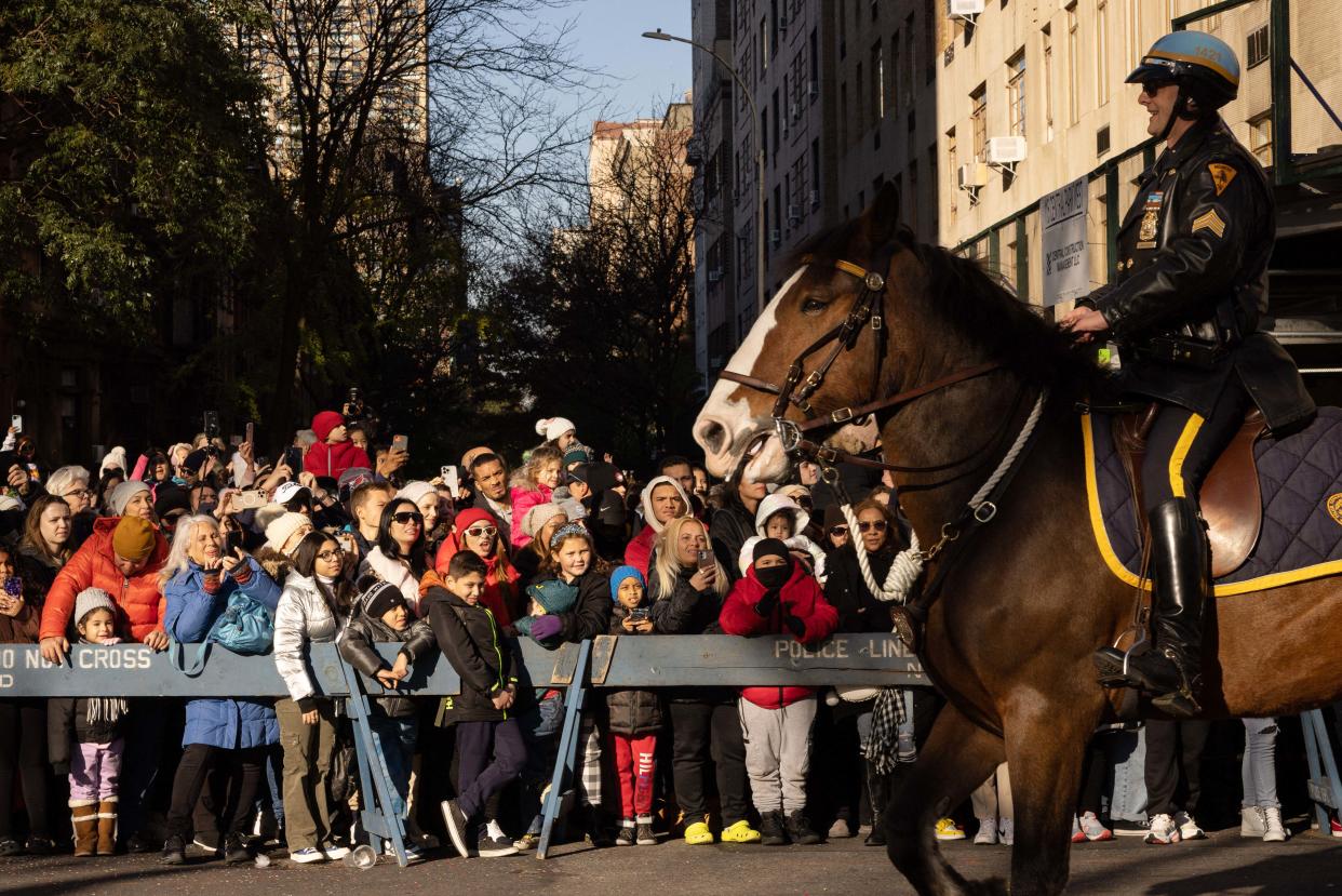 A mounted NYPD officer smiles as people take pictures during the parade.  (Yuki Iwamura / AFP via Getty Images)