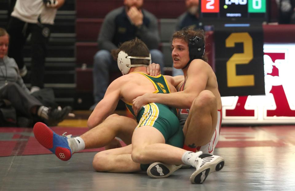 West Allegheny's Ty Watters (red) wrestles Carlynton's Chase Brandebura (green) during their 145 pound match during the MAC Wrestling Tournament Saturday afternoon at Ambridge Area High School.