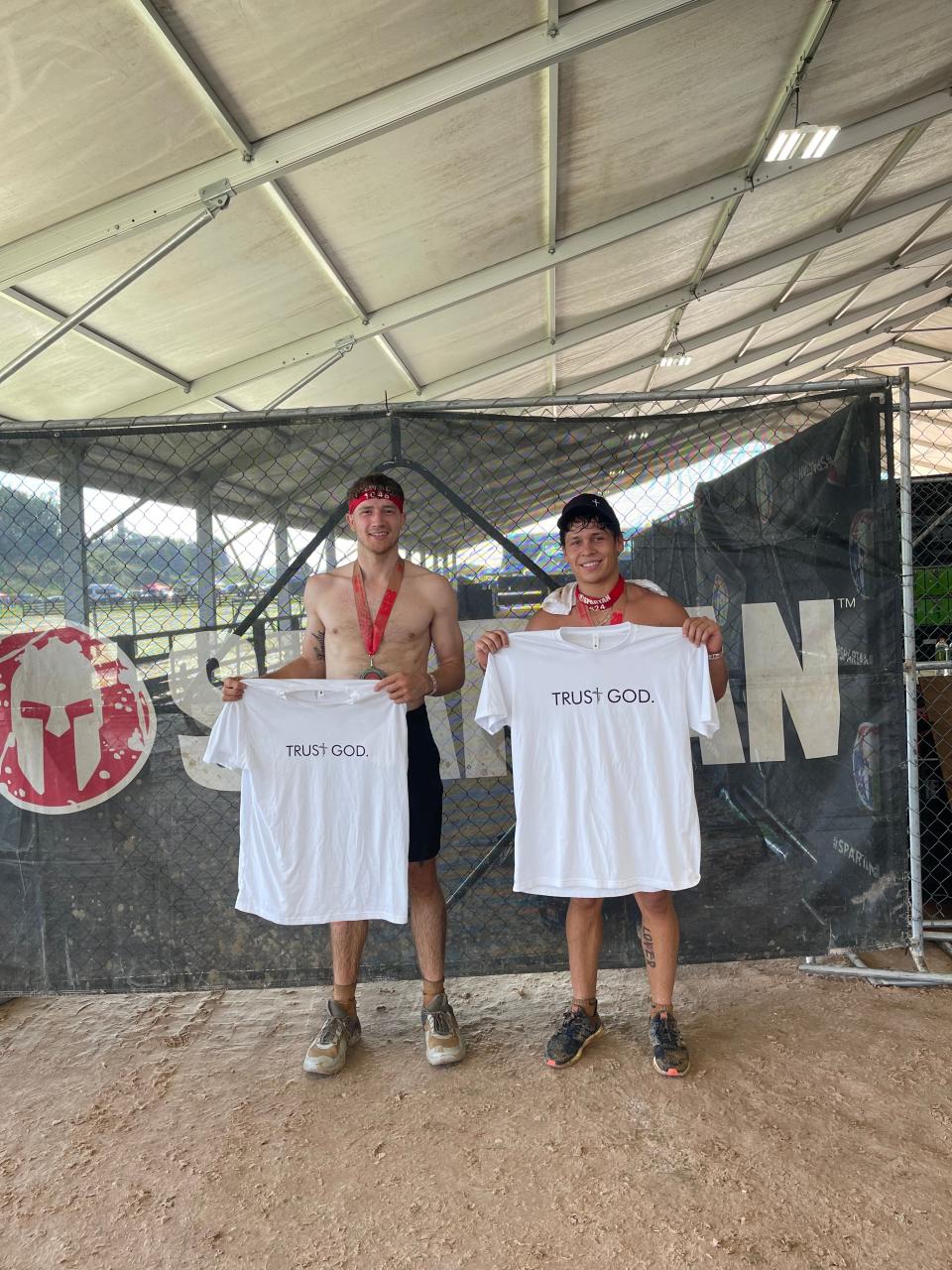 Ohio State men's basketball player Colby Baumann (left) and his friend Vic Ponce pose with shirts from Baumann's "LLP Clothing" line after running a Spartan Race.