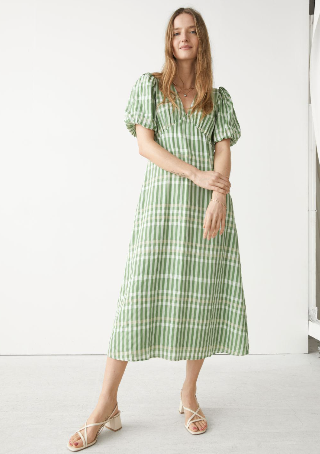 blonde model in white sandals and & Other Stories Printed Puff Sleeve Midi in Green Plaid (Photo via & Other Stories)