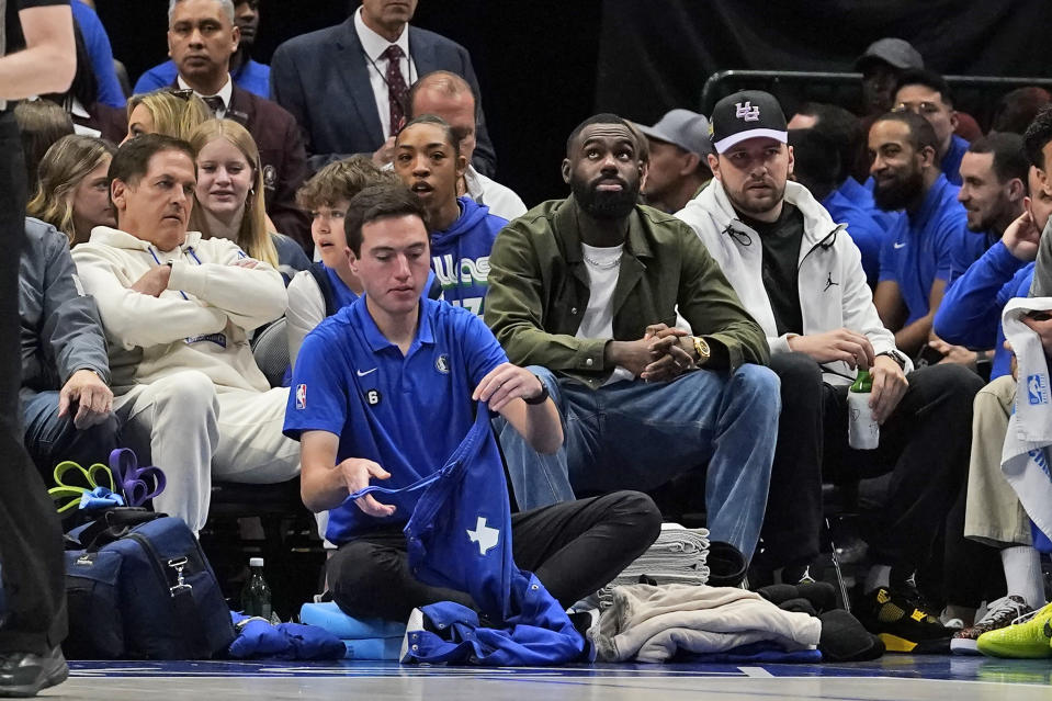 Dallas Mavericks' Luka Doncic, right, sits on the sidelines with teammate Tim Hardaway Jr., second from right and owner Mark Cuban, right, during the first quarter of an NBA basketball game against the San Antonio Spurs in Dallas, Sunday, April 9, 2023. (AP Photo/LM Otero)