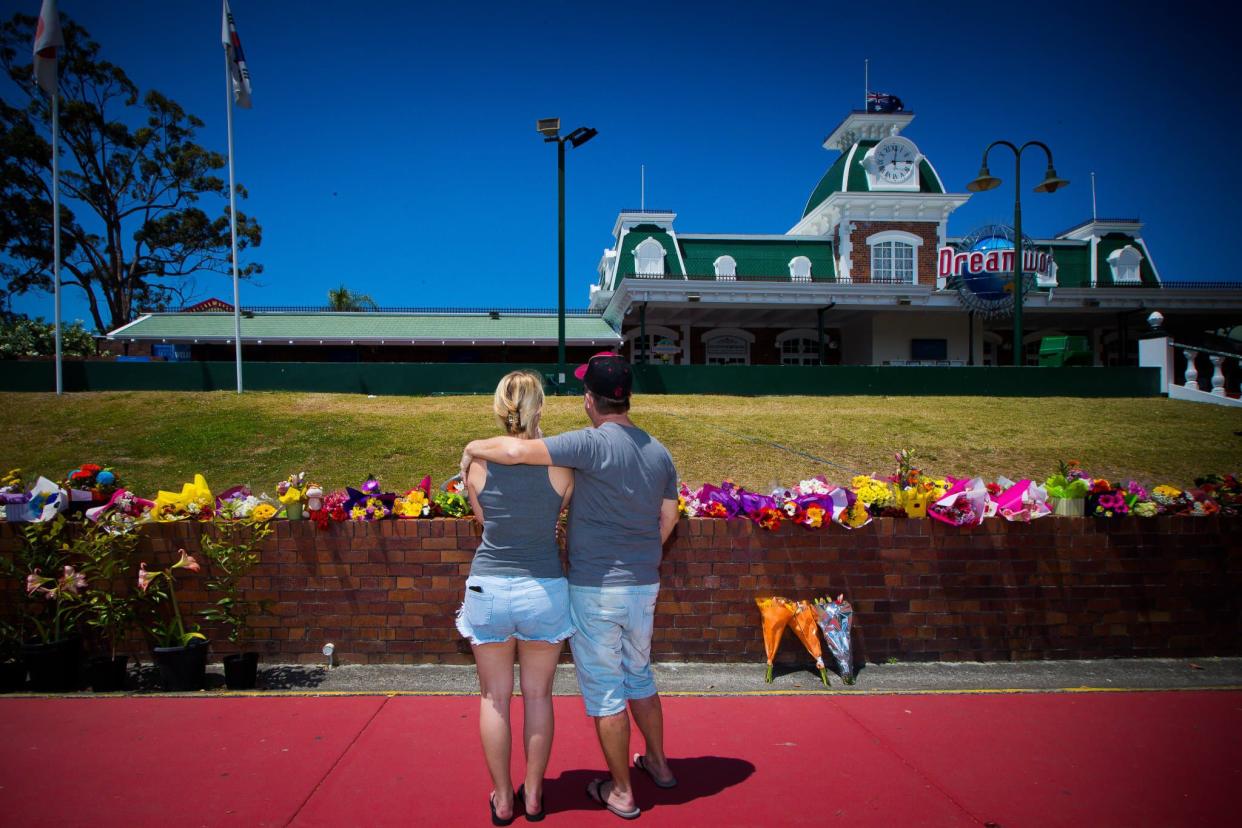 Des personnes se recueillent devant le parc d'attractions australien Dreamworld, le 26 octobre 2016 - Patrick Hamilton - AFP