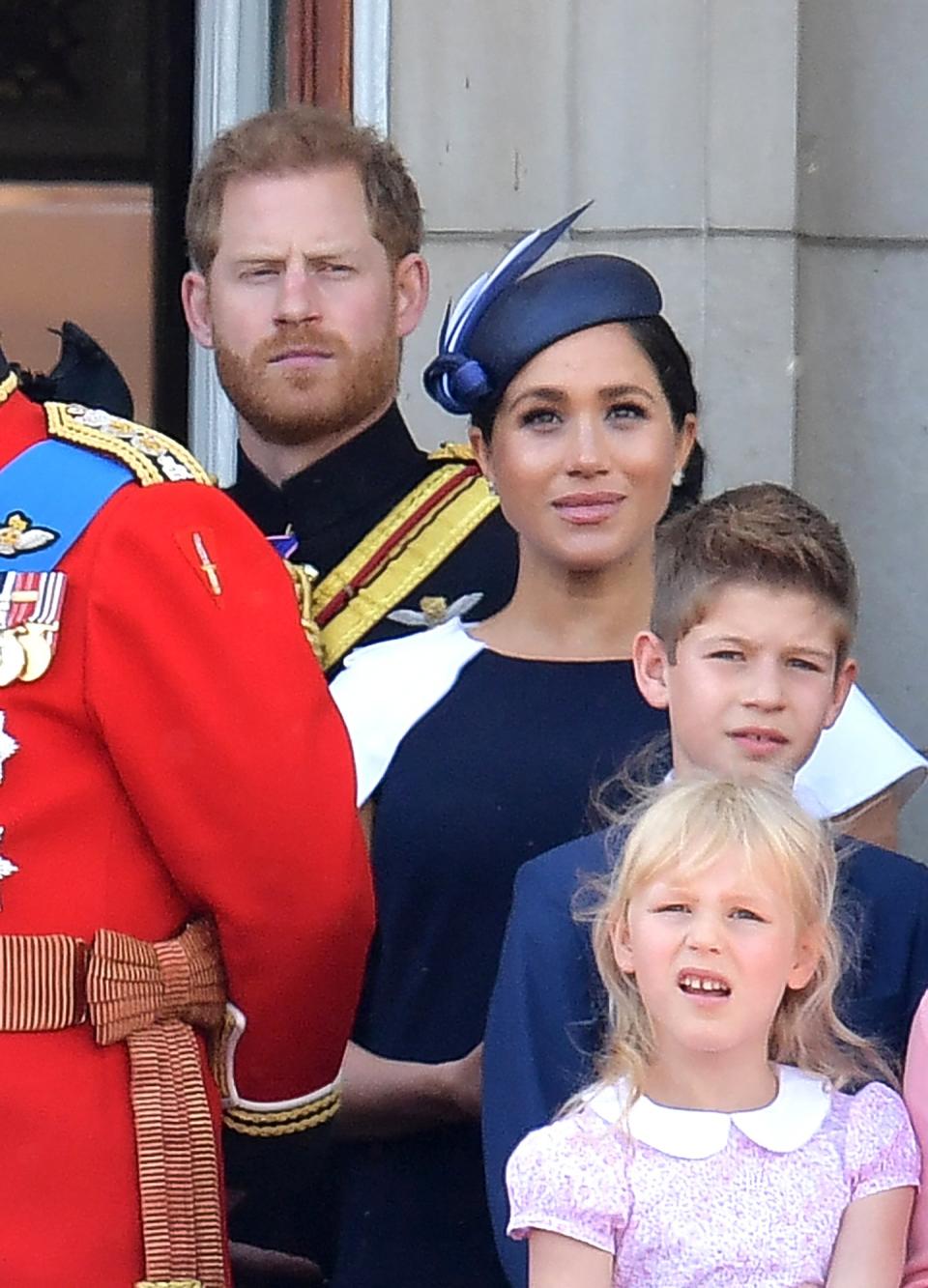 Meghan, wearing a navy blue ensemble with a matching fascinator, and Harry joined the family on the Buckingham Palace balcony to watch the flypast