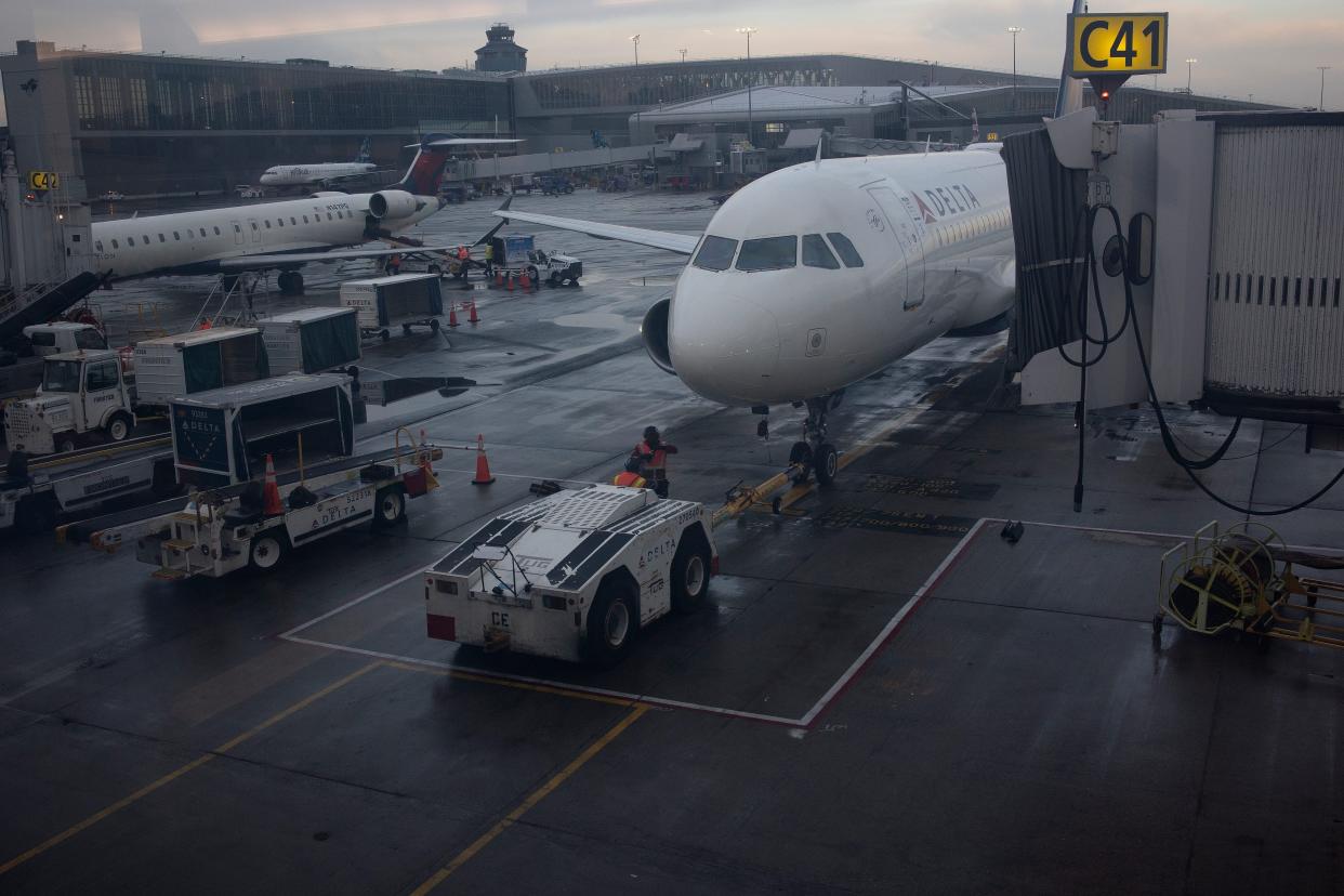 A Delta passenger plan docked to an airport jet bridge.