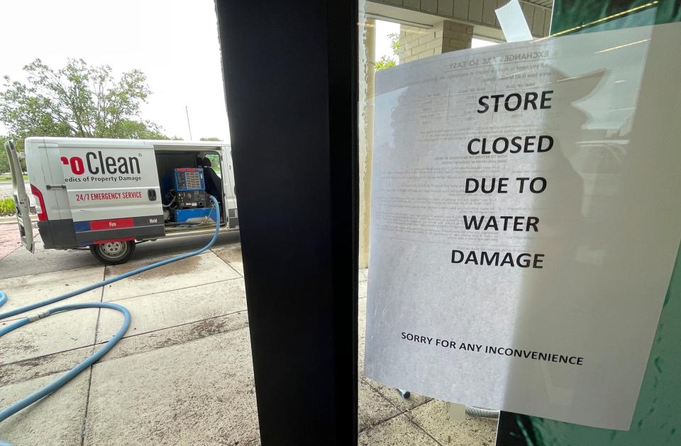 Flooding cleanup work goes on inside DSW (Designer Shoe Warehouse) at the New Towne Center strip mall near Ford and Sheldon roads in Canton as the sign on the door on Friday, Aug. 25, 2023, tells customers the store is closed. It is one of several businesses closed due to Thursday's big thunderstorm that dumped several inches of rain in the area.