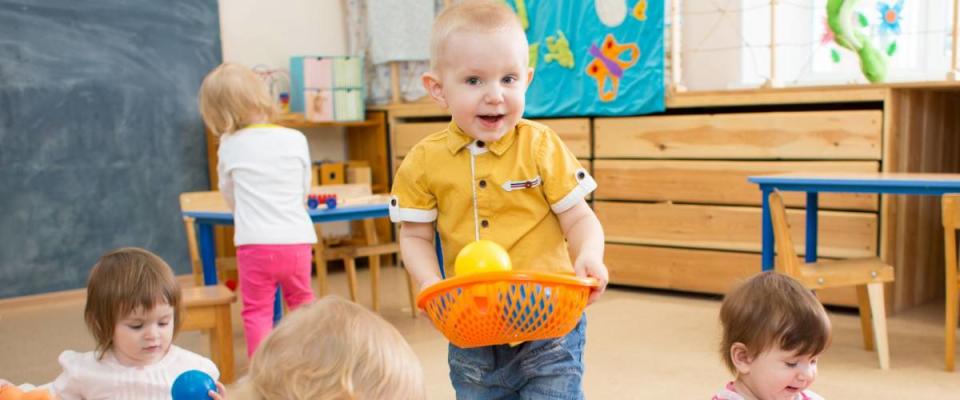 kids playing with balls in kindergarten room