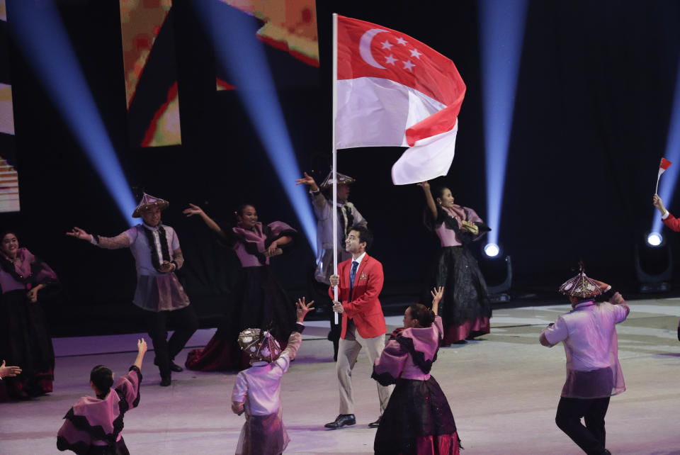 Singaporean squash athlete Samuel Kang holds their flag during the opening ceremony of the 30th South East Asian Games at the Philippine Arena, Bulacan province, northern Philippines on Saturday, Nov. 30, 2019. (AP Photo/Aaron Favila)