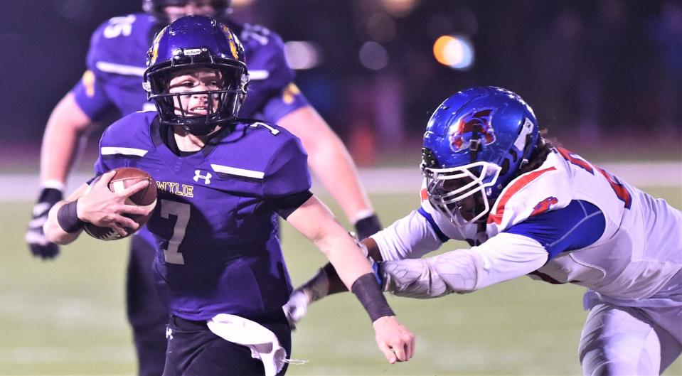 Wylie quarterback K.J. Long, left, evades Cooper's Dycin Davis for a 14-yard TD run with 3:28 left in the first quarter. It gave the Bulldogs a 7-3 lead. Wylie beat Cooper 20-10 in the District 2-5A Division II game Nov. 4 at Sandifer Stadium.