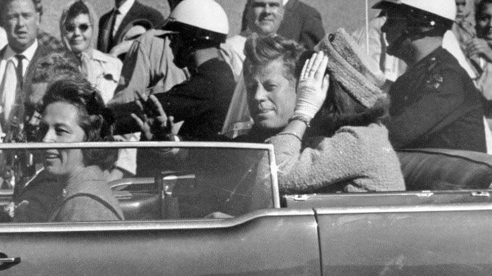 John F. Kennedy waves to crowds in Dallas just before the fatal shot was fired. Photo: AP