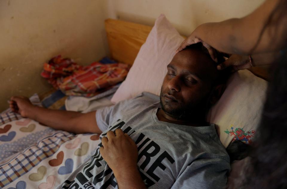 Priyantha Kumarasinghe has his head massaged by a relative at his aunt's home in Homagama (Reuters)