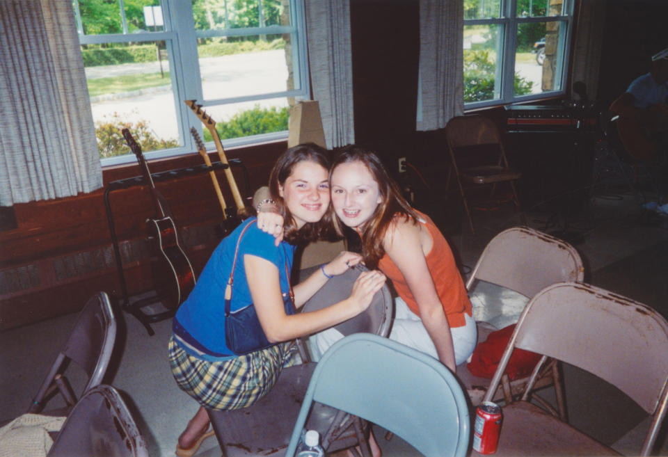 Two young girls are hugging each other