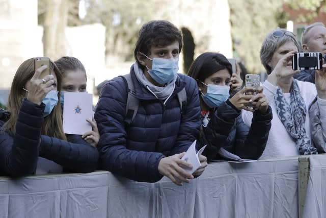 People wear surgical masks as they wait for the arrival of Pope Francis outside the Santa Sabina Basilica on Ash Wednesday