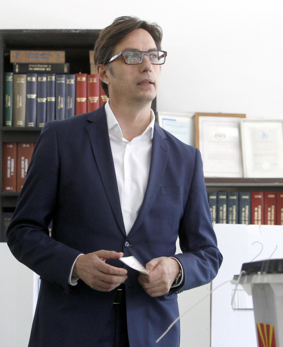 Stevo Pendarovski, a presidential candidate of the ruling coalition led by the Social Democrats, holds his ballot before voting for the presidential elections at a polling station in Skopje, North Macedonia, Sunday, April 21, 2019. North Macedonia holds the first round of presidential elections on Sunday, seen as key test of the government following deep polarization after the country changed its name to end a decades-old dispute with neighboring Greece over the use of the term "Macedonia". (AP Photo/Boris Grdanoski)