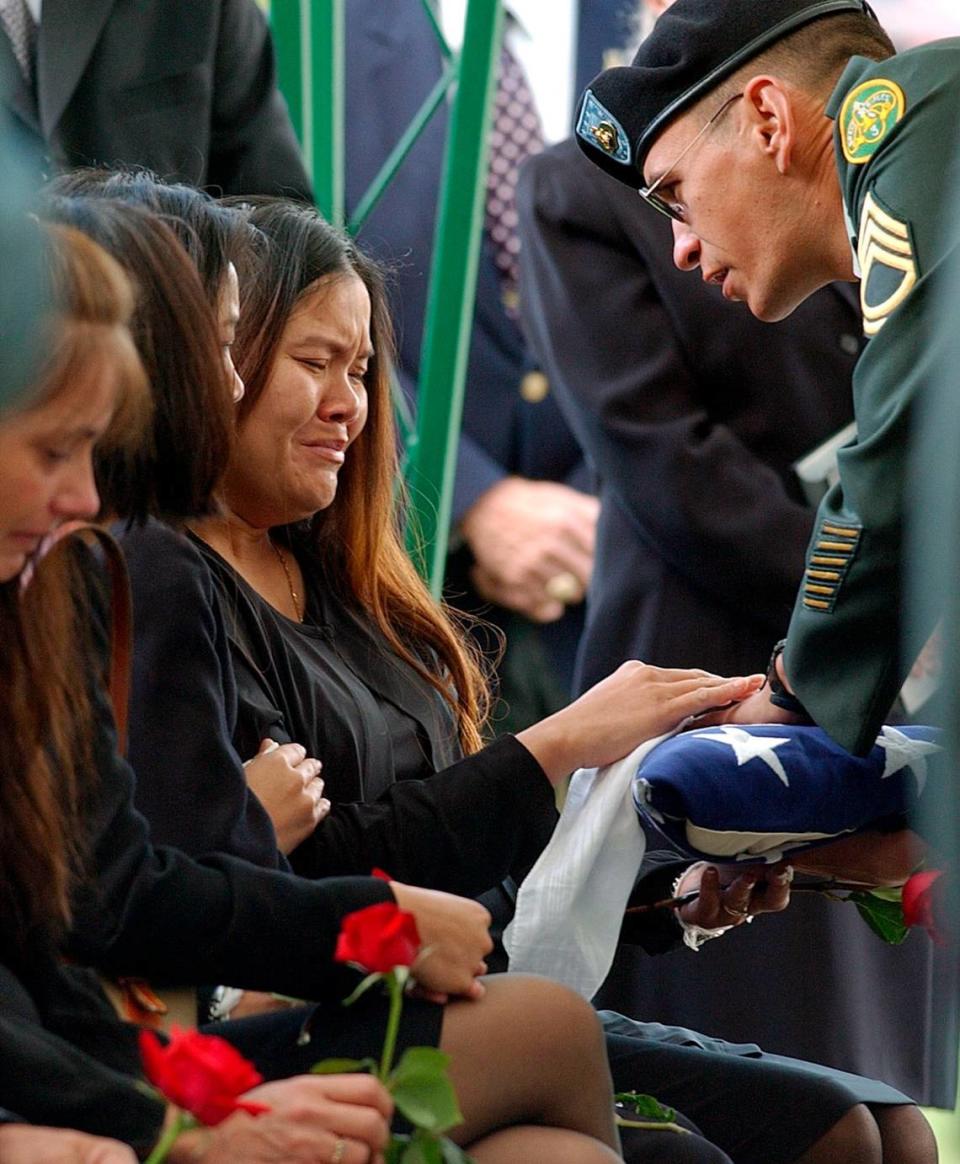 Jamie Miller, widow of Army Staff Sg. Fred Miller, who was killed in Iraq the previous week, tearfully accepts the flag which was draped upon her husband’s casket from sergeant 1st class Michael Reed, at the Brigadier General William C. Doyle Veteran’s Memorial Cemetary on Sept. 29, 2003.