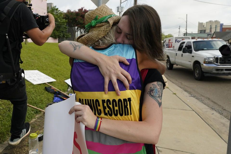 Derenda Hancock, co-director of the Jackson Women's Health Organization clinic patient escorts, better known as the Pink House defenders, left, hugs a tearful abortion rights supporter Sonnie Bane, outside the Jackson Women's Health Organization clinic in Jackson, Miss., Wednesday, July 6, 2022. The clinic is the only facility that performs abortions in the state. However, on Tuesday, a chancery judge rejected a request by the clinic to temporarily block a state law banning most abortions. Without other developments in the Mississippi lawsuit, the clinic will close at the end of business Wednesday and the state law will take effect Thursday. (AP Photo/Rogelio V. Solis)