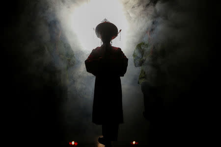 Medium An Chinh walks through smoke during a Hau Dong performance at the Viet Theatre in Hanoi, Vietnam, March 9, 2017. REUTERS/Kham