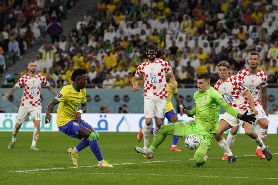 El delantero brasileño Vinicius Junior (izquierda) remata ante el arquero croata Marcelo Brozovic Dominik Livakovic en el partido por los cuartos de final del Mundial, el viernes 9 de diciembre de 2022, en Rayán, Qatar. (AP Foto/Martin Meissner)