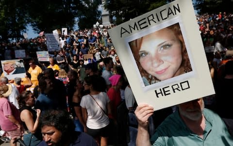 A counterprotester holds a photo of Heather Heyer on Boston Common at a "Free Speech" rally  - Credit: AP