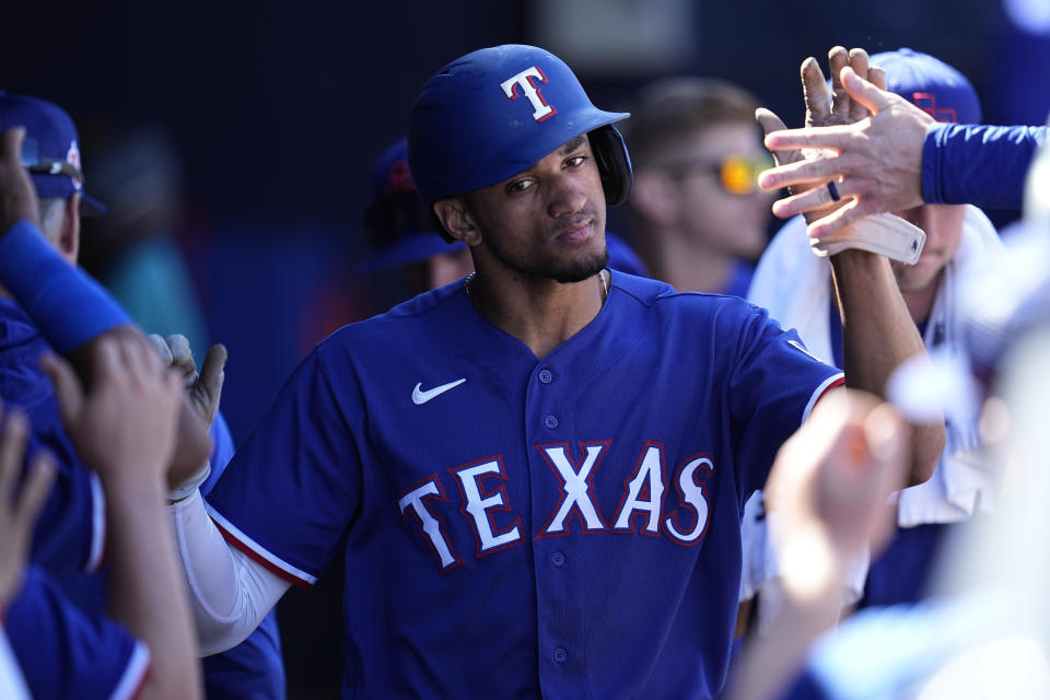 Texas Rangers' Bubba Thompson celebrates in the dugout after scoring during the fifth inning of a spring training baseball game against the Seattle Mariners, Sunday, March 12, 2023, in Peoria, Ariz. (AP Photo/Abbie Parr)