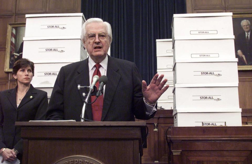 Surrounded by boxes of evidence against President Clinton, House Judiciary Committee Chairman Rep. Henry Hyde, R-Ill., accompanied by committee member Rep. Mary Bono, R-Calif., gestures during a Capitol Hill news conference.