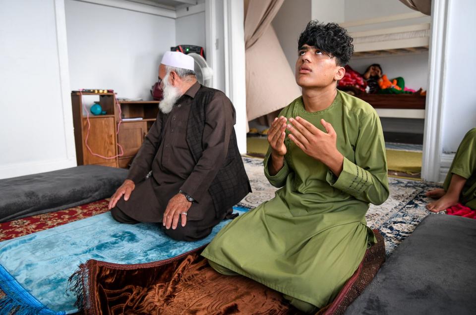 Aug 7, 2023; Buffalo, NY, USA Mohammad Shams, 14, right, and his father, Mohammad Hakim Hotak, 68, participate in Salah - one of five daily prayers they recite as Muslims, at their home in Buffalo, N.Y., Tuesday, August 7, 2023. Shams brother, Mohammed Shams, 14, arrived alone to the USA in November 2021, just two months after the fall of Kabul. He didn't speak English and had no other relatives with him. At the two-year anniversary of the U.S.'s hasty retreat from Afghanistan, authorities continue to struggle with what to do with the remaining Afghan youths in U.S. custody.