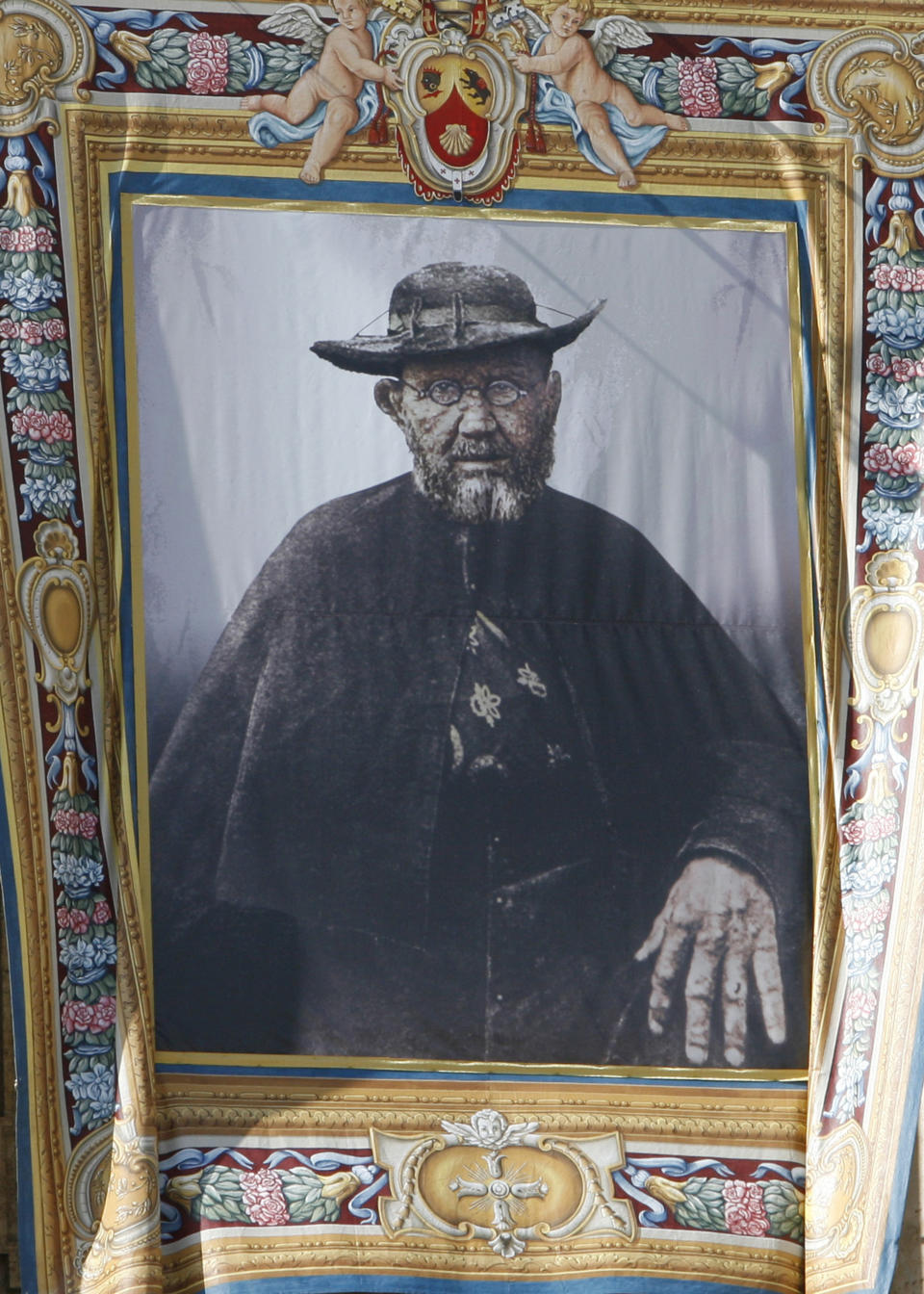 FILE - A tapestry depicting Father Damien, born as Joseph De Veuster, hanging from the St. Peter Basilica facade during a canonization ceremony in St. Peter's square at the Vatican, Oct. 11, 2009. Damien has long been a saint to the people of Hawaii for caring for exiled leprosy patients in the mid-1800s on the Kalaupapa peninsula on the island of Molokai when no one else would, and then contracting and dying of the disfiguring disease himself. (AP Photo/Alessandra Tarantino, File)