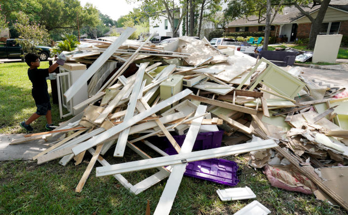 Jay Jackson adds to the pile of trash from Harvey flood damage.