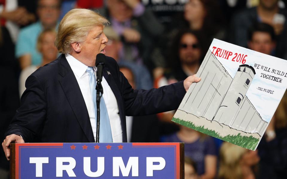 U.S. Republican presidential candidate Donald Trump holds a sign supporting his plan to build a wall between the United States and Mexico that he borrowed from a member of the audience at his campaign rally in Fayetteville, North Carolina March 9, 2016. (Photo: REUTERS/Jonathan Drake)