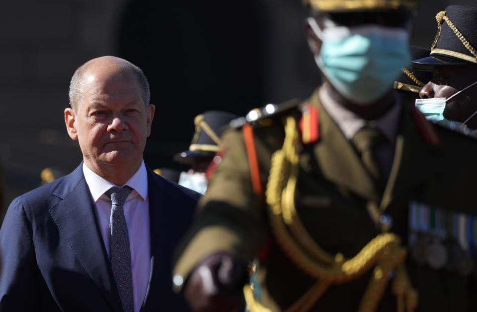 German Chancellor Olaf Scholz, left, walks as he inspects a guard of honour during the official welcoming ceremony at the Union Building in Pretoria, South Africa, Tuesday, May 24, 2022. (AP Photo/Themba Hadebe)