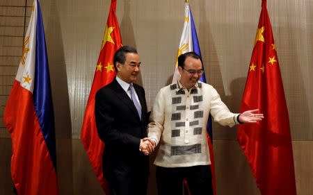 Philippine Foreign Affairs Secretary Alan Peter Cayetano escorts visiting China's Foreign Minister Wang Yi before a bilateral meeting in Taguig, Metro Manila Philippines July 25, 2017. REUTERS/Erik De Castro