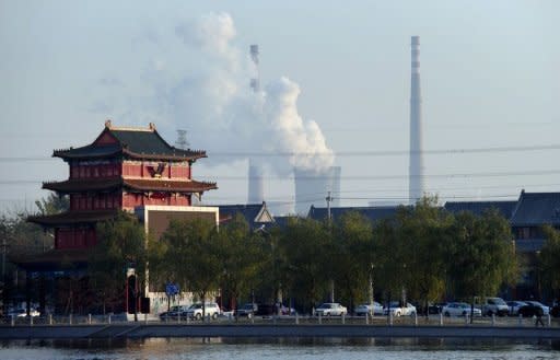 A building in traditional style stands near the cooling towers and smokestack chimneys of a coal-fired power plant on the outskirts of Beijing in 2010. Carbon dioxide emitted by energy use hit a record high last year, dimming prospects for limiting global warming to two degrees Celsius, the International Energy Agency (IEA) said Monday