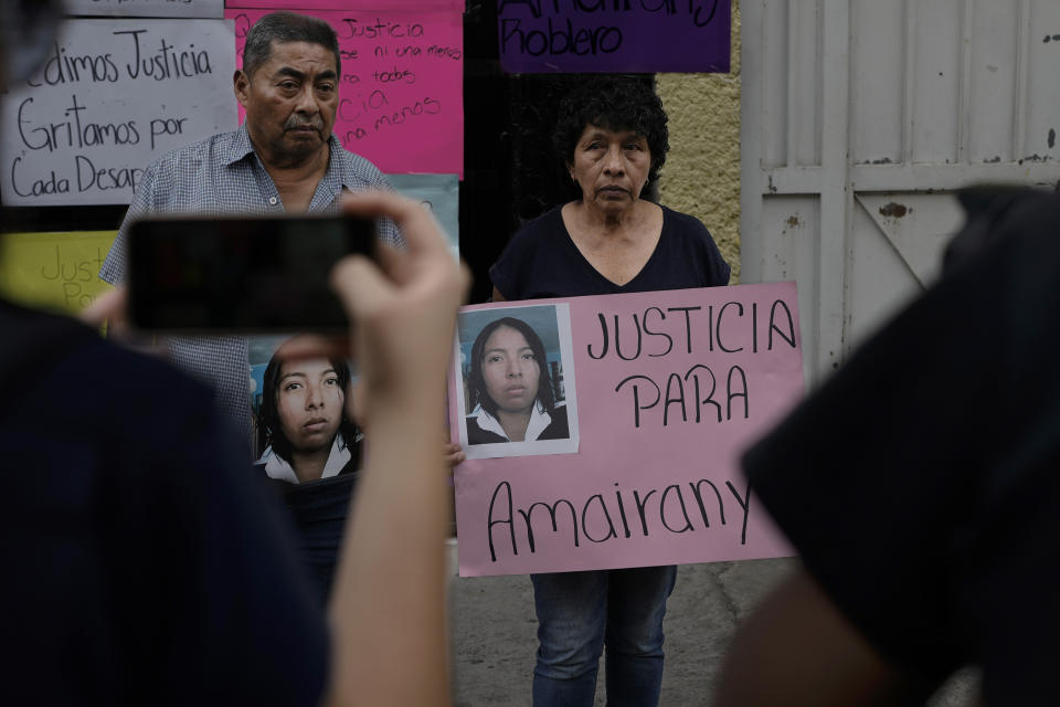 Mario Roblero and Cecilia Gonzalez hold images of their missing daughter Amarirany Roblero, during a protest outside an apartment rented by a suspected serial killer, in the Iztacalco neighborhood of Mexico City, Friday, April 26, 2024. Protesters covered the facade of the building with placards after investigators found the bones, cell phones and ID cards of several women at rented rooms there, asking variants of a single question: Why did it take prosecutors 12 years to investigate the disappearance of Amairany Roblero, then 18. (AP Photo/Marco Ugarte)