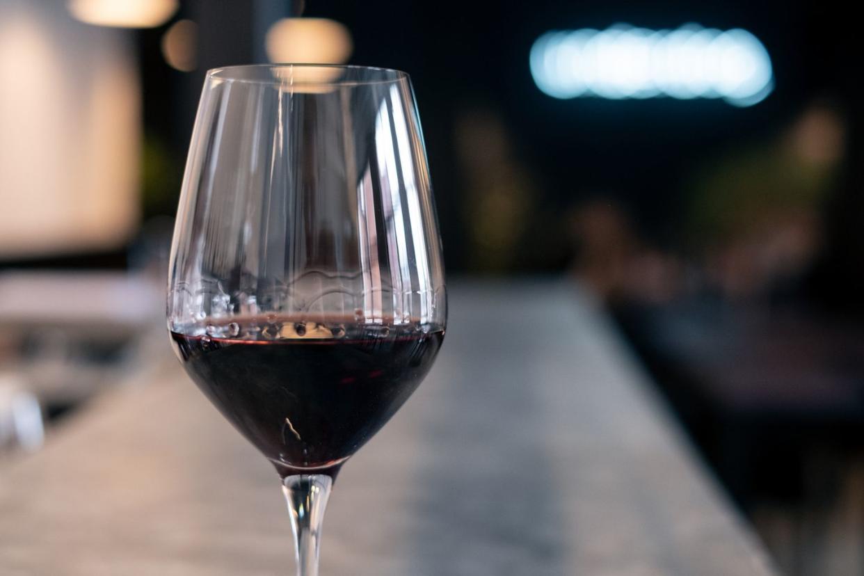 close up of a glass of red wine on a bar counter