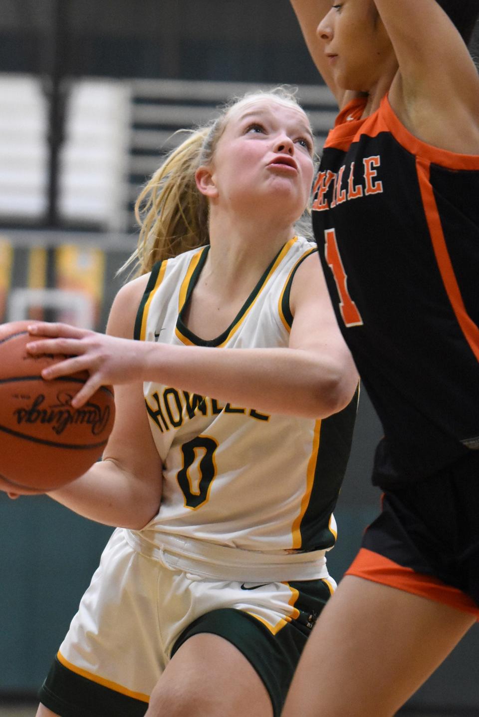 Howell's Caitlyn Rayl drives to the basket while defended by Belleville's Rylan Buschell during the Highlanders' 54-53 victory on Tuesday, Dec. 20, 2022.