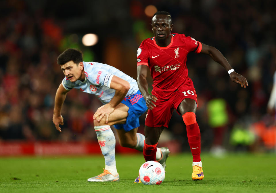 LIVERPOOL, ENGLAND - APRIL 19: Harry Maguire of Manchester United looks on as Sadio Mane of Liverpool runs with the ball during the Premier League match between Liverpool and Manchester United at Anfield on April 19, 2022 in Liverpool, England. (Photo by Clive Brunskill/Getty Images)