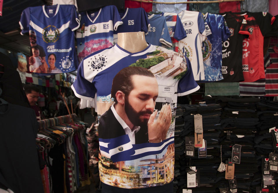 FILE - In this March 13, 2021 file photo, a jersey emblazoned with an image of El Salvador's President Nayib Bukele is displayed for sale at a market in San Salvador, El Salvador. Bukele enjoys an approval rating of more than 90% among people who saw three of four previous presidents jailed or exiled for corruption. (AP Photo/Salvador Melendez, File)