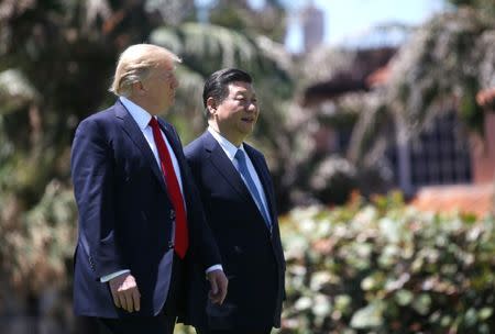 U.S. President Donald Trump (L) and China's President Xi Jinping walk along the front patio of the Mar-a-Lago estate after a bilateral meeting in Palm Beach, Florida, U.S., April 7, 2017. REUTERS/Carlos Barria