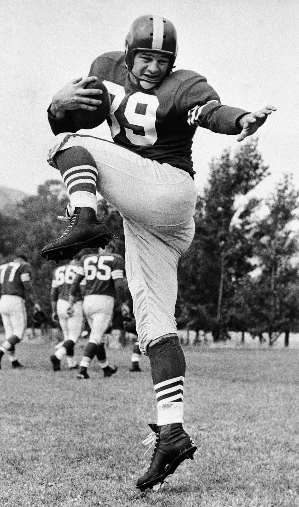 Hugh McElhenny, who was the National Professional League?s leading ground gainer last year until injured displays hit cut away style for the camera during first day workout on July  20, 1955 in Moraga, Calif. many sports writers linked the downfall on the ?49?ers last year to the injury suffered by McElhenney in Midseason.