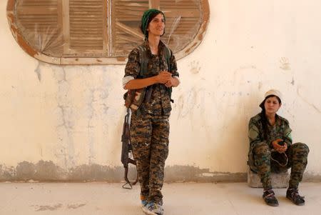 Sheen Ibrahim, Kurdish fighter from the People's Protection Units (YPG) talk to her friends in Raqqa, Syria June 16, 2017. REUTERS/Goran Tomasevic