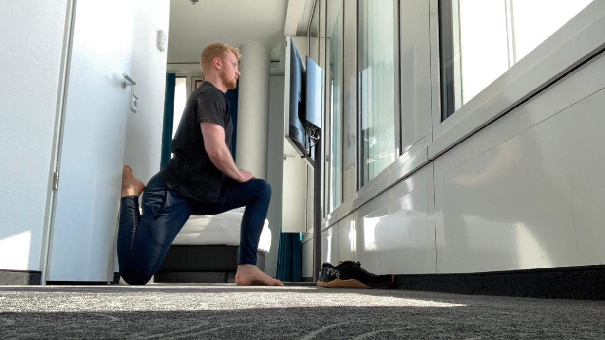  Man performing a stretch in a hotel room 