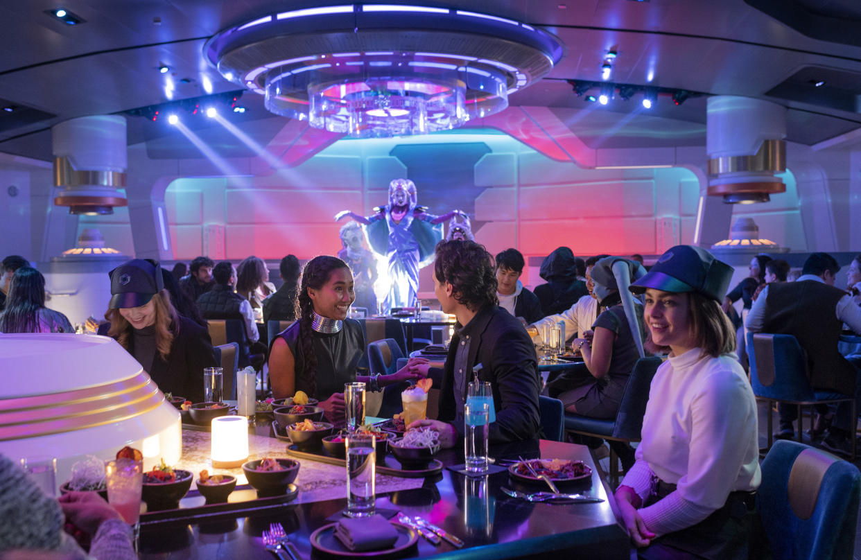 On one evening of the two-night voyage, Galactic Starcruiser passengers dine while galactic pop star Gaya performs in the Crown of Corellia dining room. (Photo: Walt Disney World Resort)