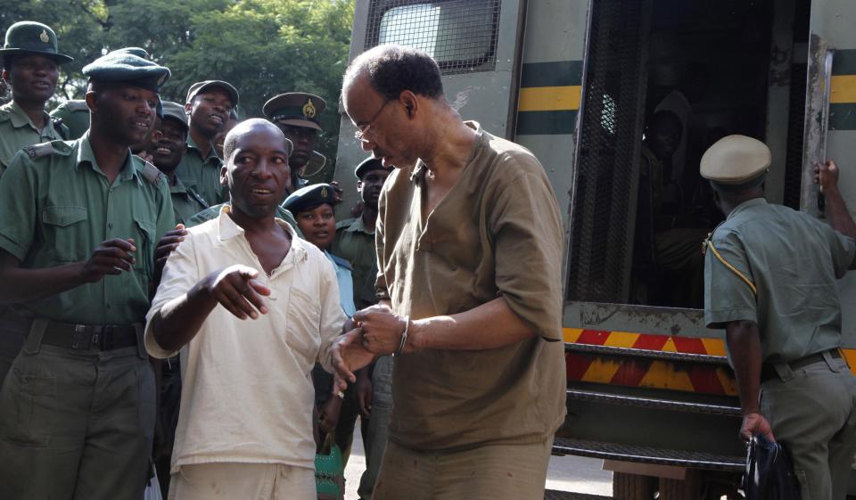 Former U.S. congressman Mel Reynolds (C) arrives at the Harare Magistrates court, February 20, 2014. Reynolds pleaded not guilty on Wednesday to charges of possessing pornographic images and videos, two days after his arrest at a hotel in Zimbabwe. Reynolds, 62, a convicted sex offender in the United States, also faces charges of staying in the southern African country without a valid visa. REUTERS/Philimon Bulawayo (ZIMBABWE - Tags: POLITICS CRIME LAW)